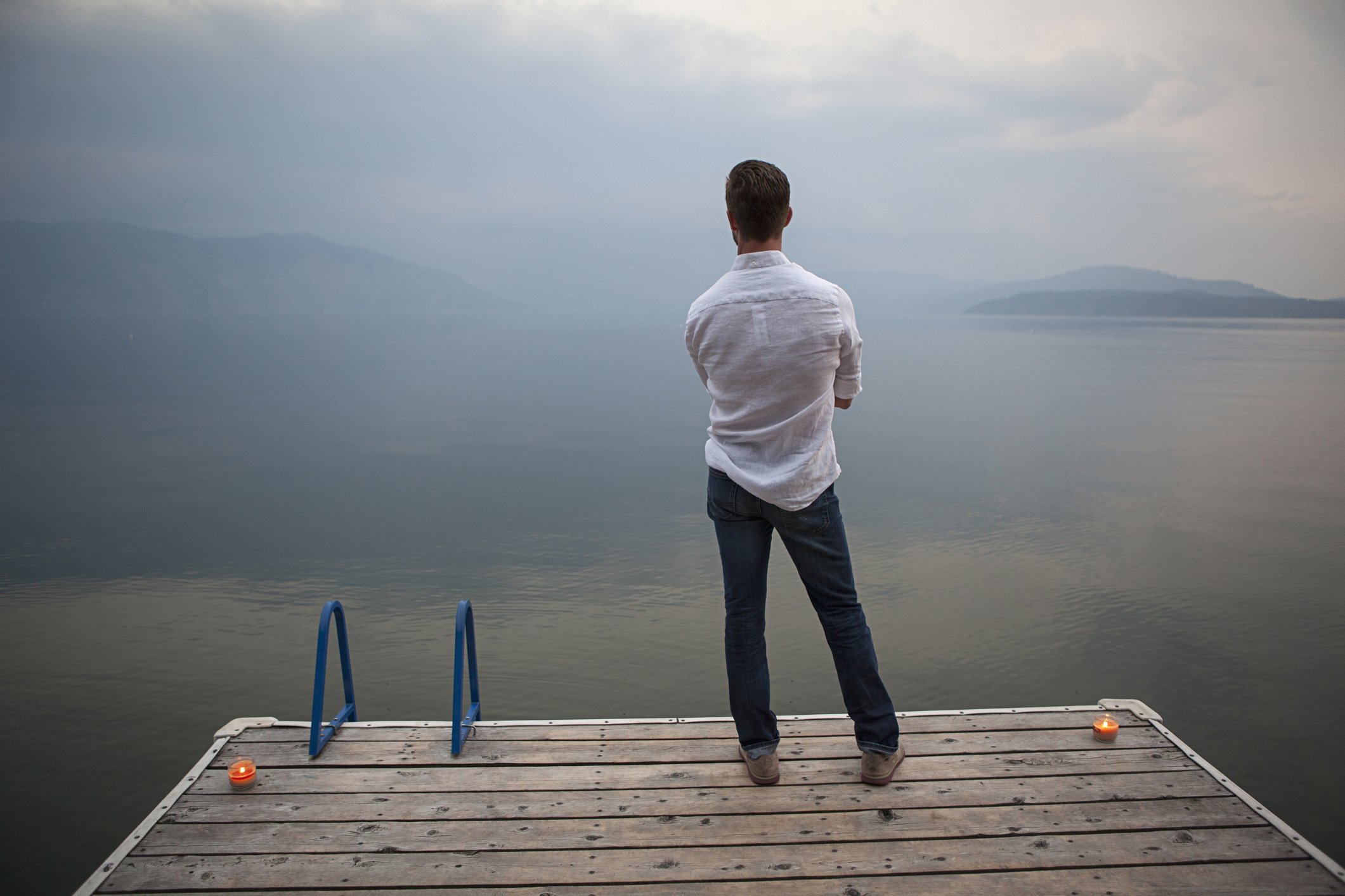 Фотография на тему Молодой мужчина стоит спиной на белом фоне | PressFoto