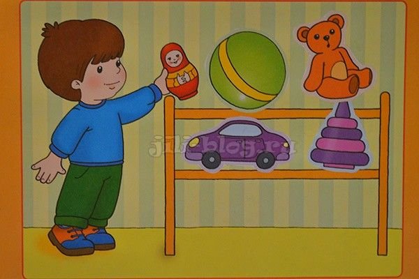 Ребенок ставит игрушки на полку