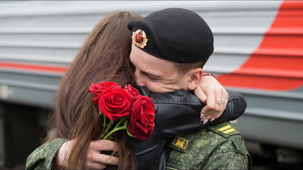 Девушка солдат. Встреча солдата. Военный с цветами. Солдат обнимает.