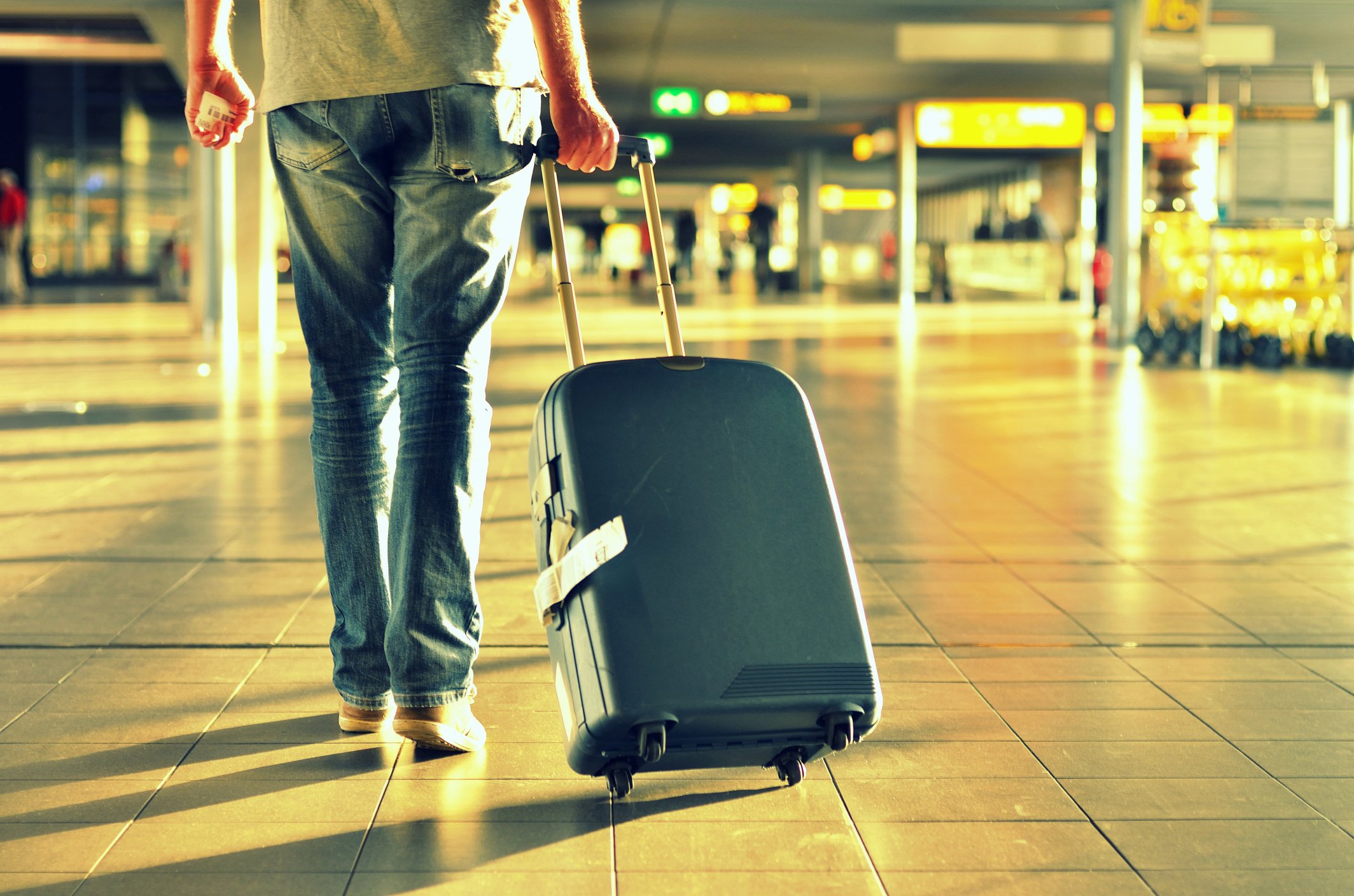 Уезжать куча. Человек с чемоданом. Мужчина с чемоданом в аэропорту. Парень с чемоданом в аэропорту. Человек с багажом.