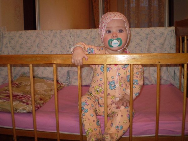Малыши в кроватке с пустышкой
