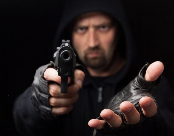 Угрожает пистолетом